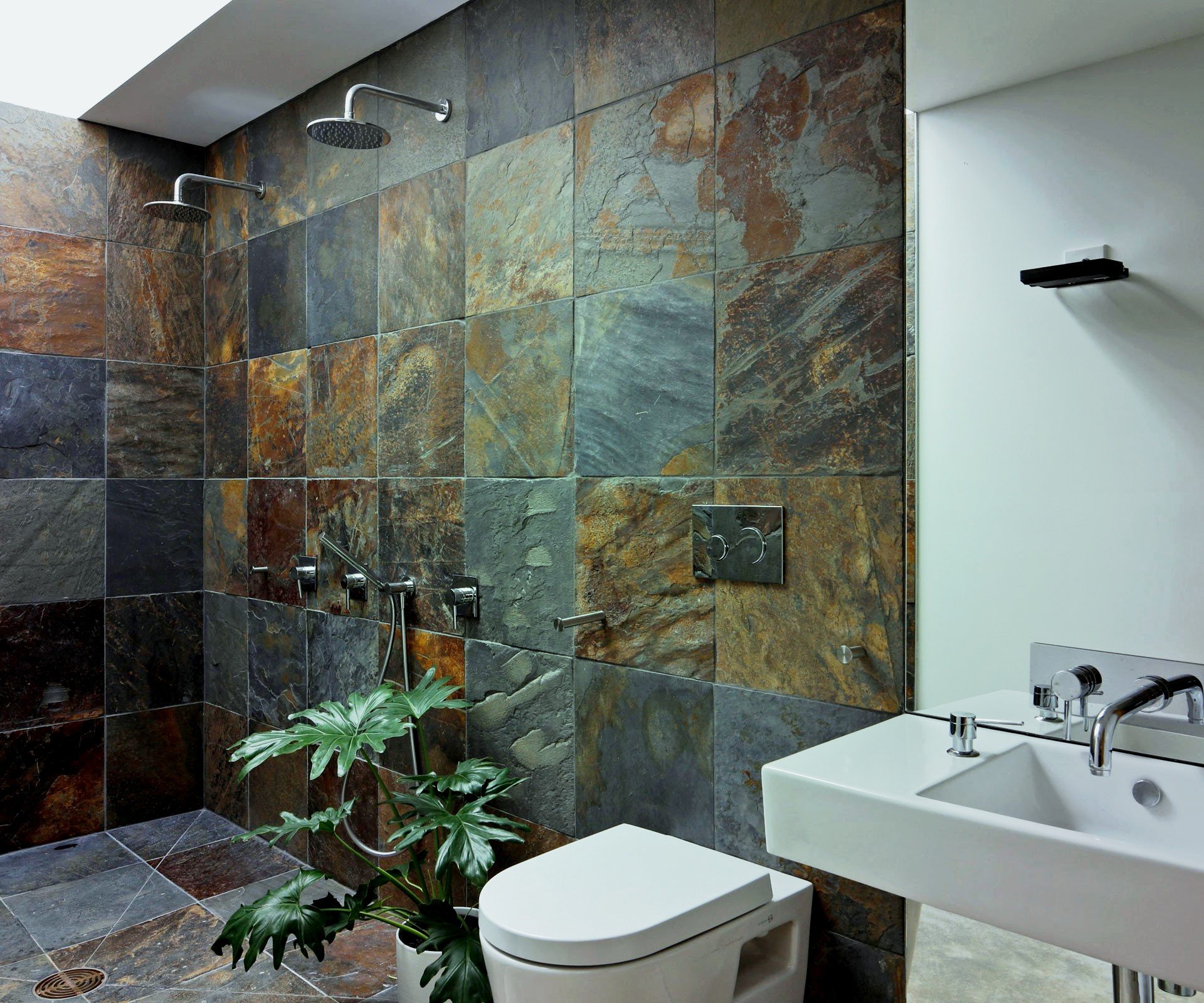 A bathroom with a toilet a sink and a shower.