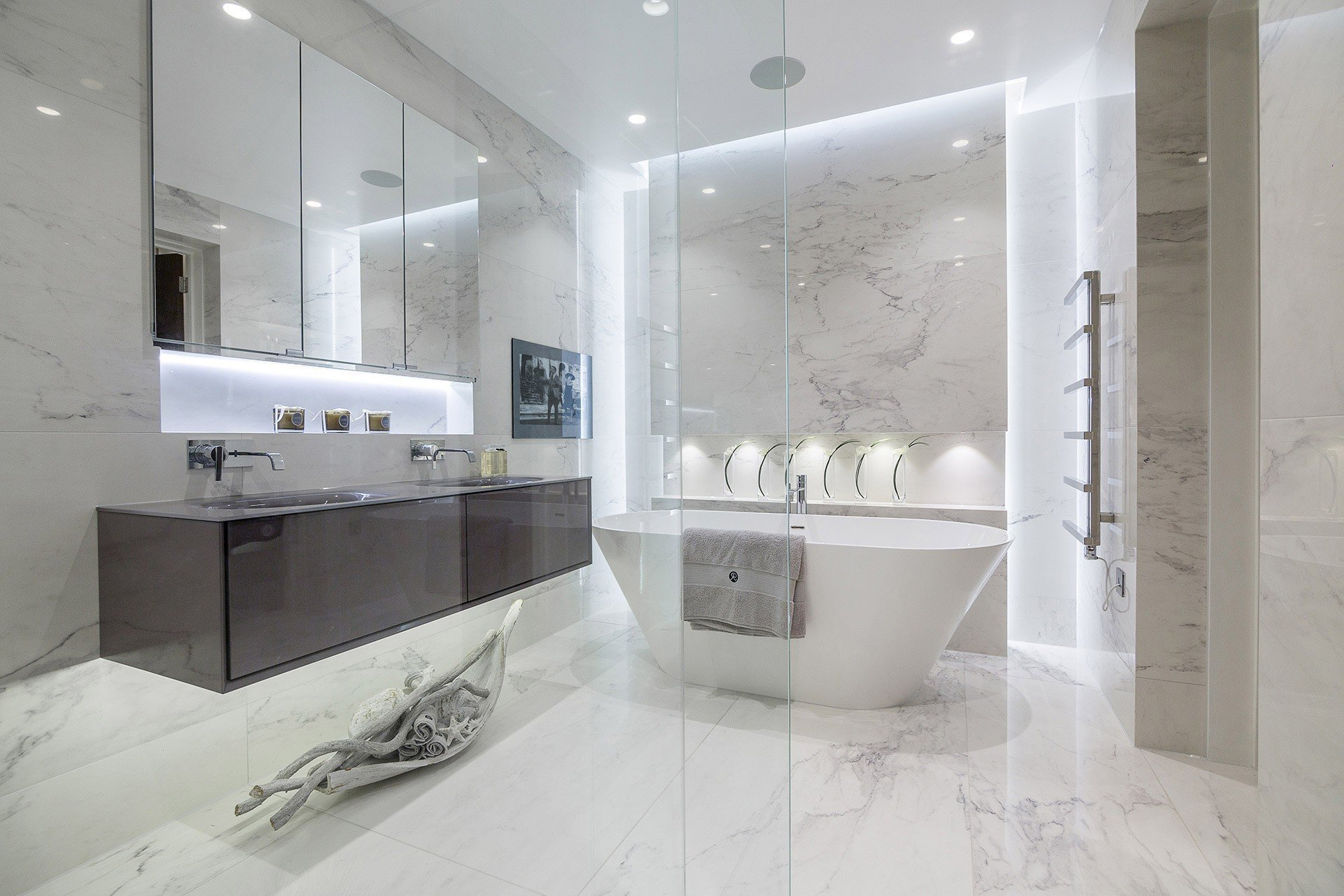 A bathroom with a bathtub, sinks, mirrors and a walk in shower.