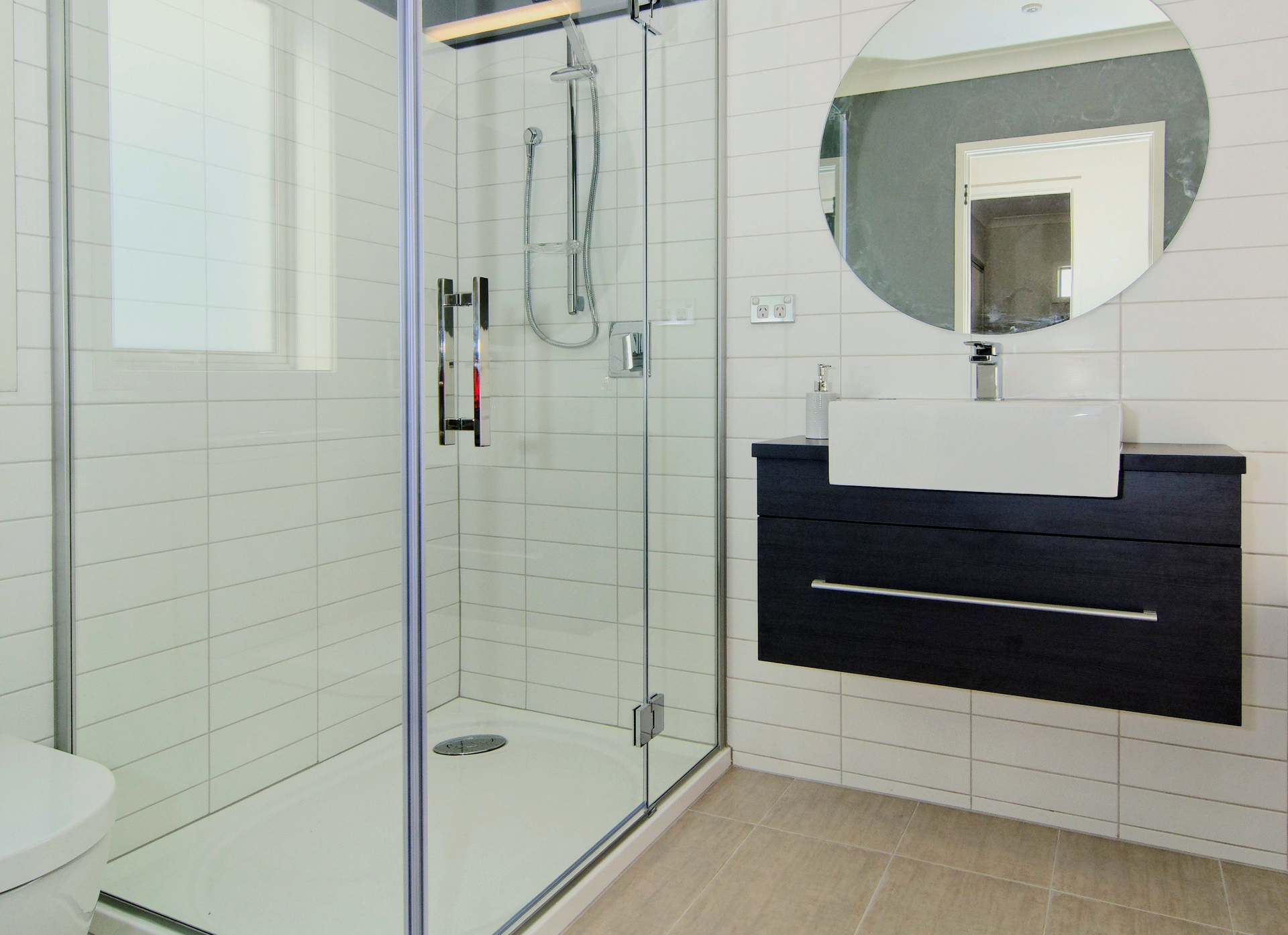 A bathroom with a walk in shower and a sink.