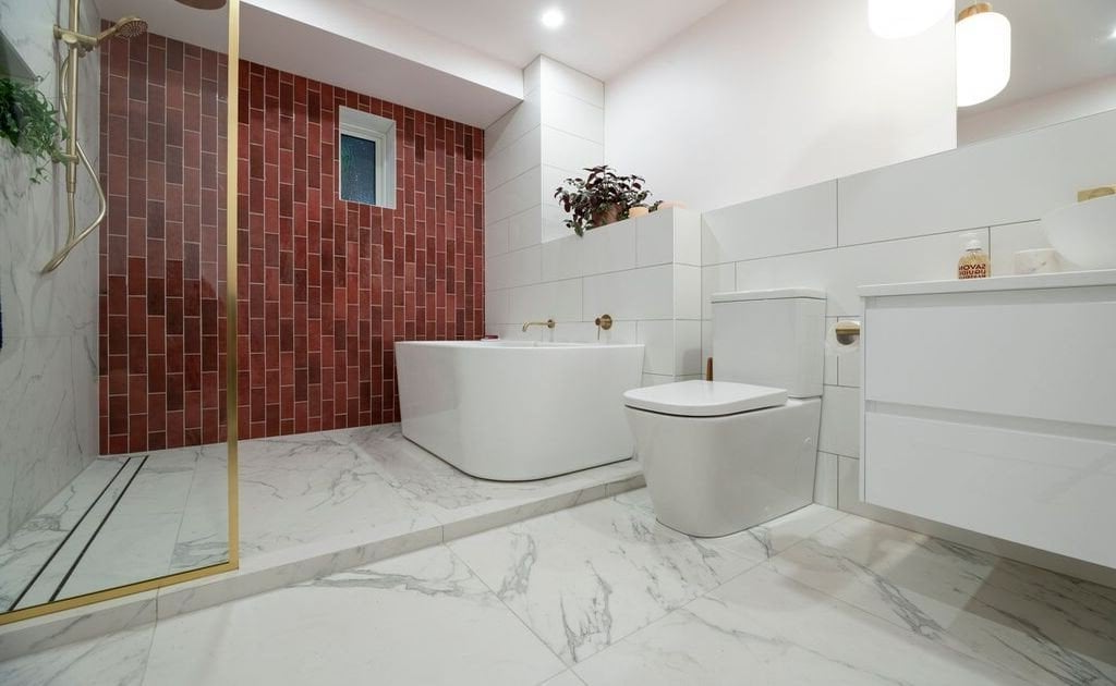 A bathroom with a tub, toilet, sink and shower.