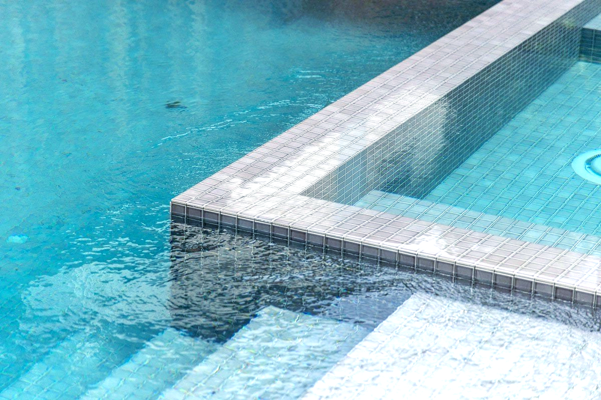 A close up of a swimming pool with stairs leading to it.