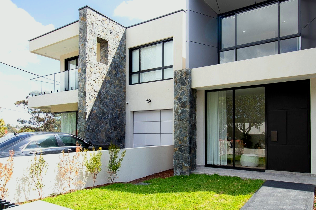 A modern house with a car parked in front of it.