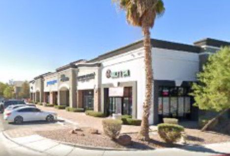 Woman pharmacist smiling in front of shelves of beauty products.