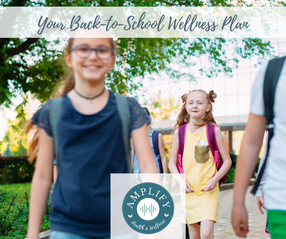 A group of children with backpacks are walking down a sidewalk.