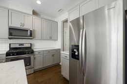 Gray kitchen with stainless steel appliances, cabinets, and white countertops.