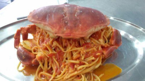 vassoio di spaghetti al sugo con grosso granchio