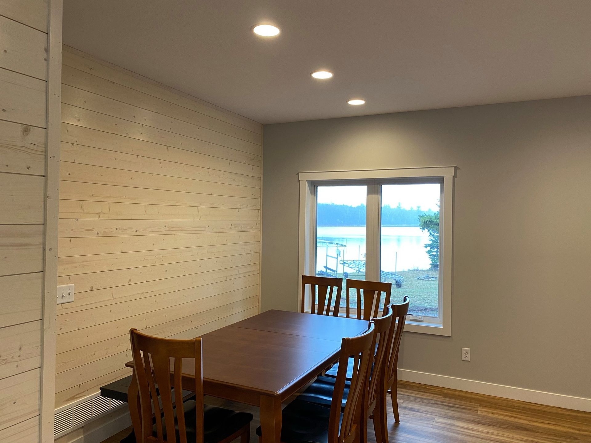 A dining room with a table and chairs and a window.