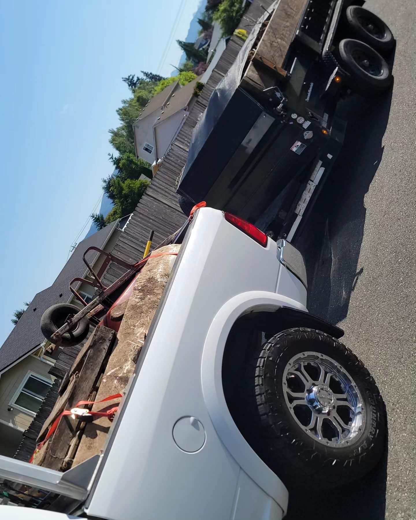 A white truck is parked next to a black truck