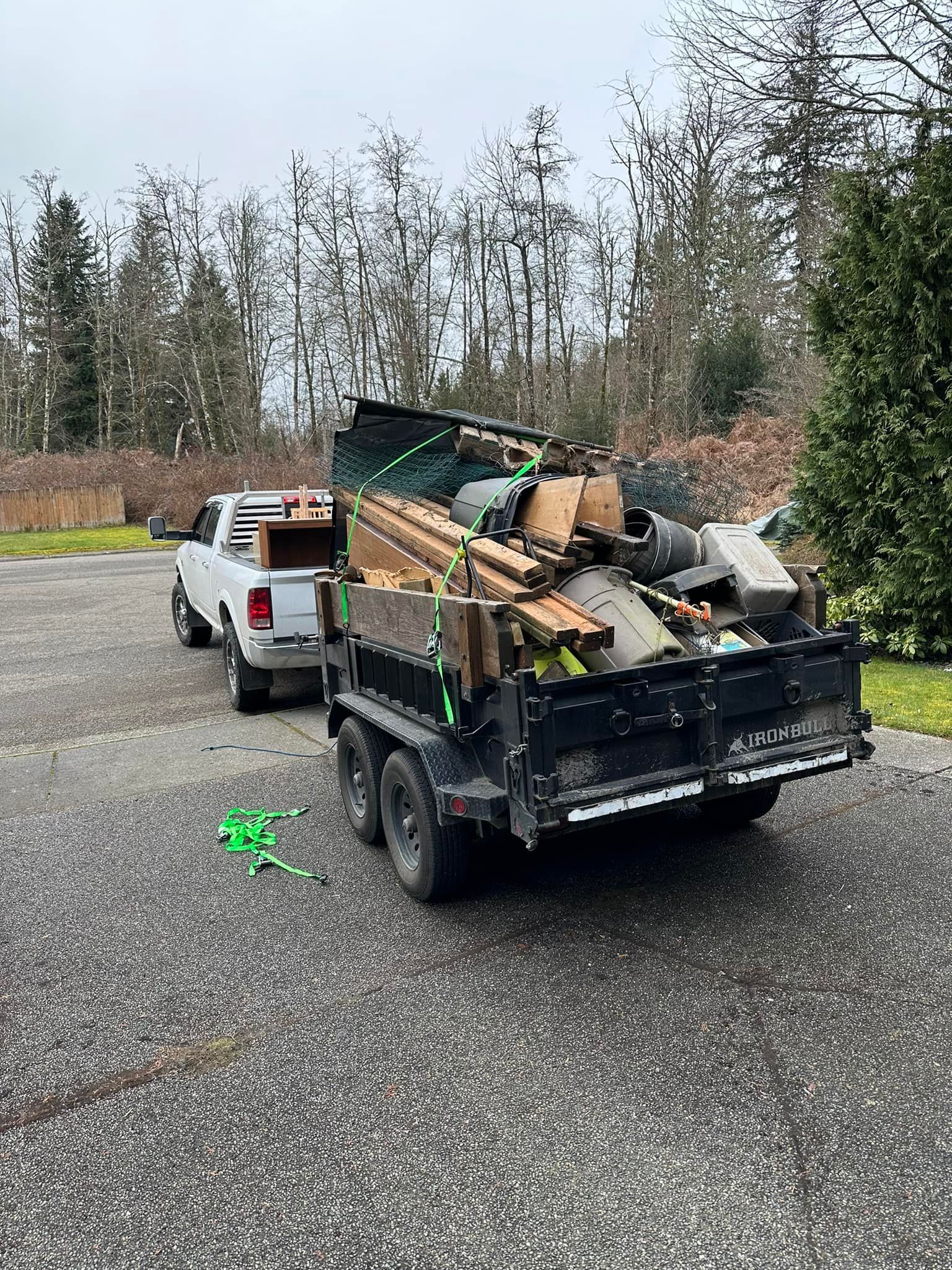A dump truck is pulling a trailer full of wood.