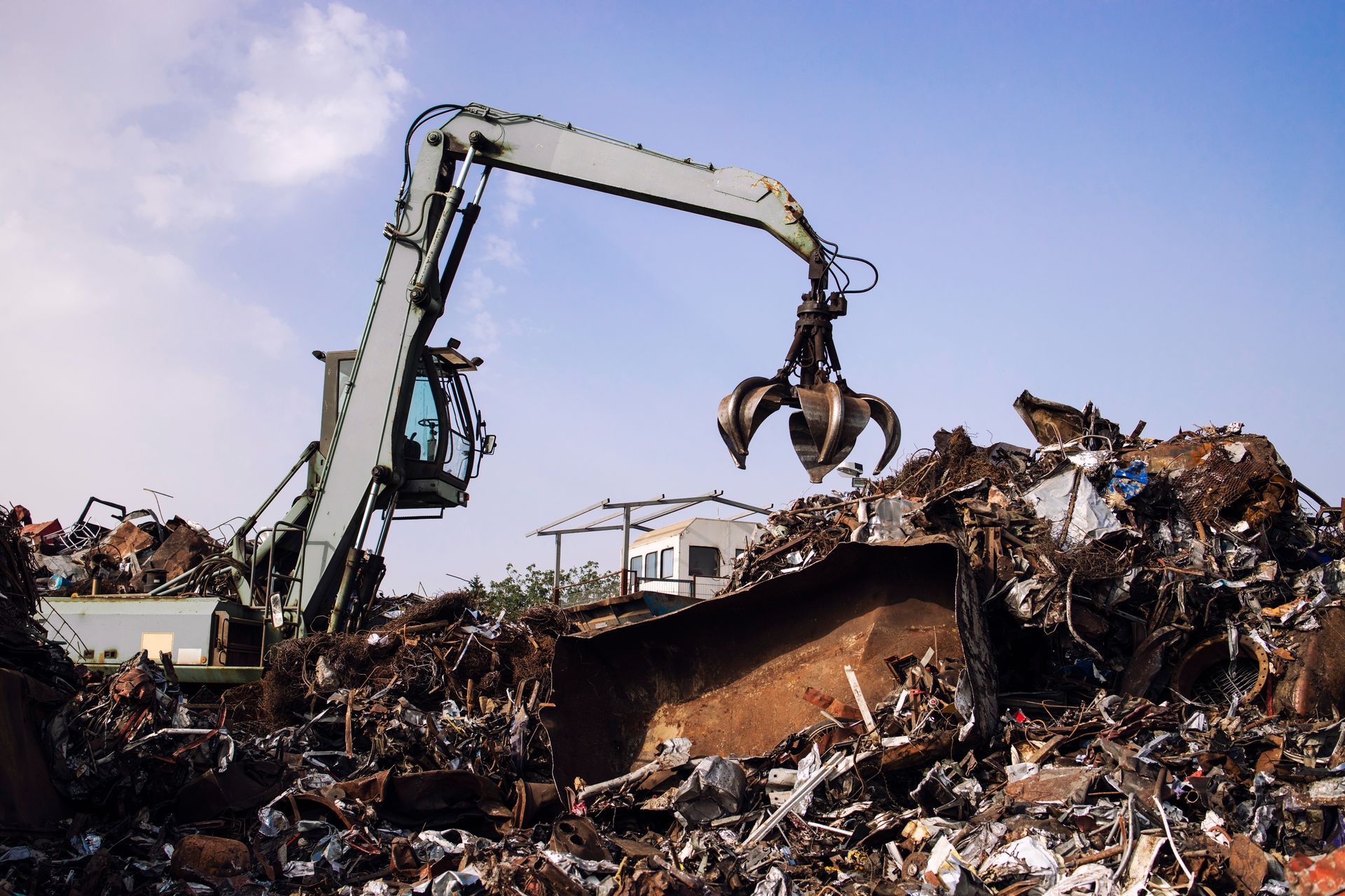 a bulldozer is moving a pile of scrap metal in a scrap yard .
