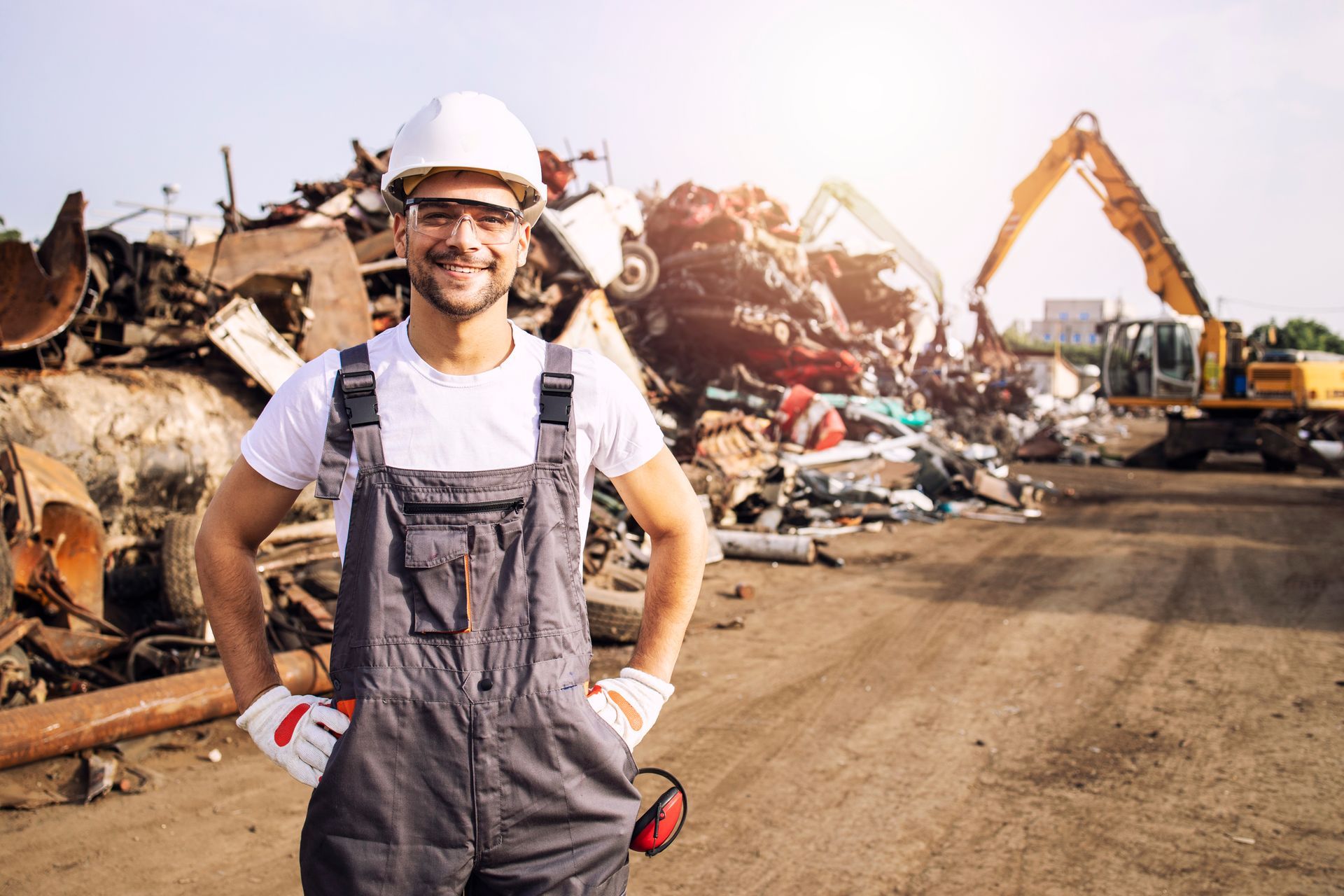 a man is standing in front of a pile of scrap metal .