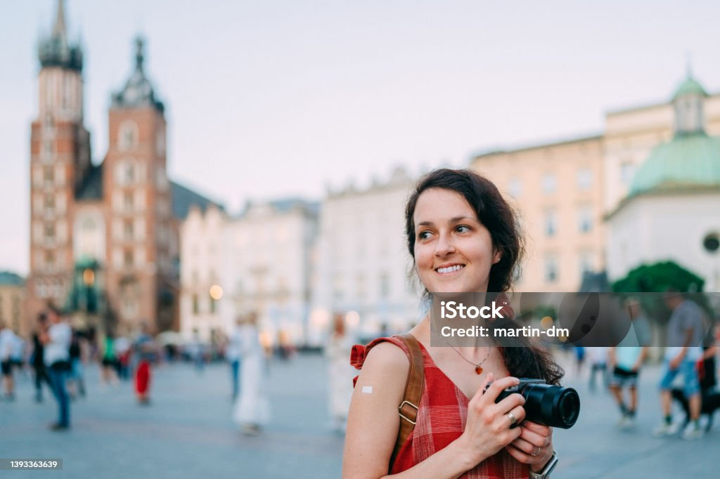 A woman is taking a picture of a city with a camera.