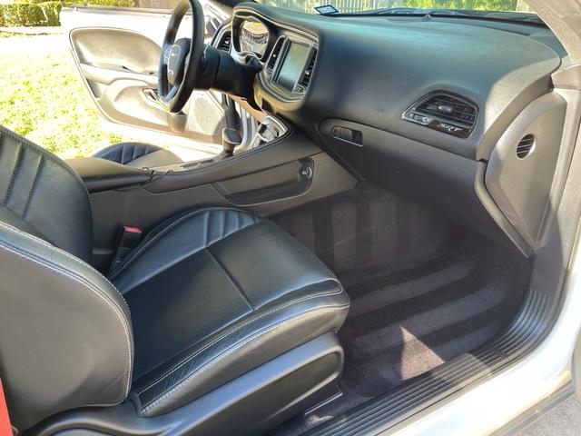The interior of a white dodge challenger with black seats