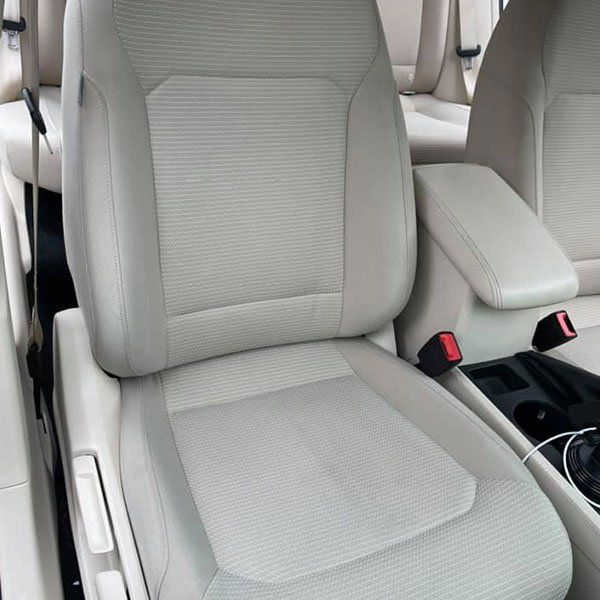 A close up of a car seat with a red buckle