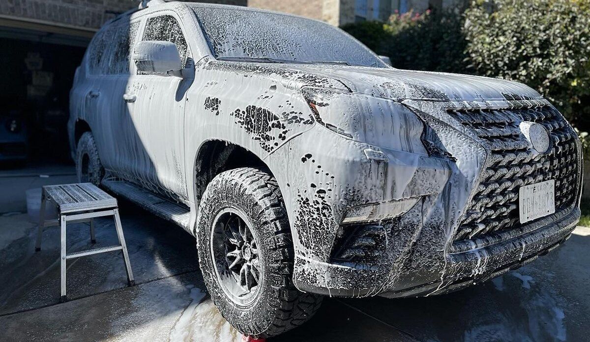 A green sports car is parked in a parking lot.
