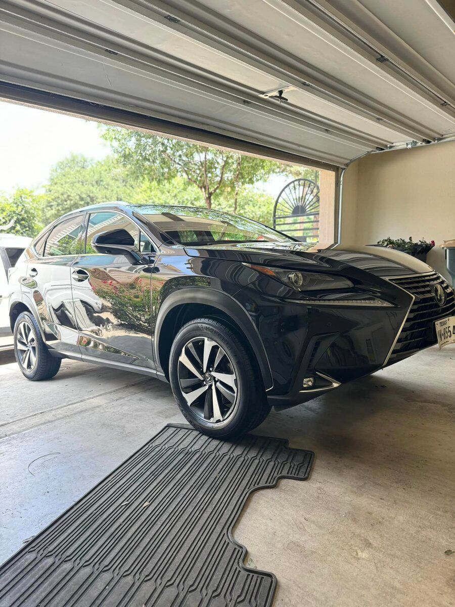 A person is washing a car with a sponge and soap.