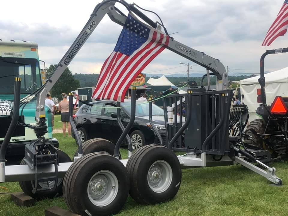 A red bulldozer is parked on the side of a dirt road.