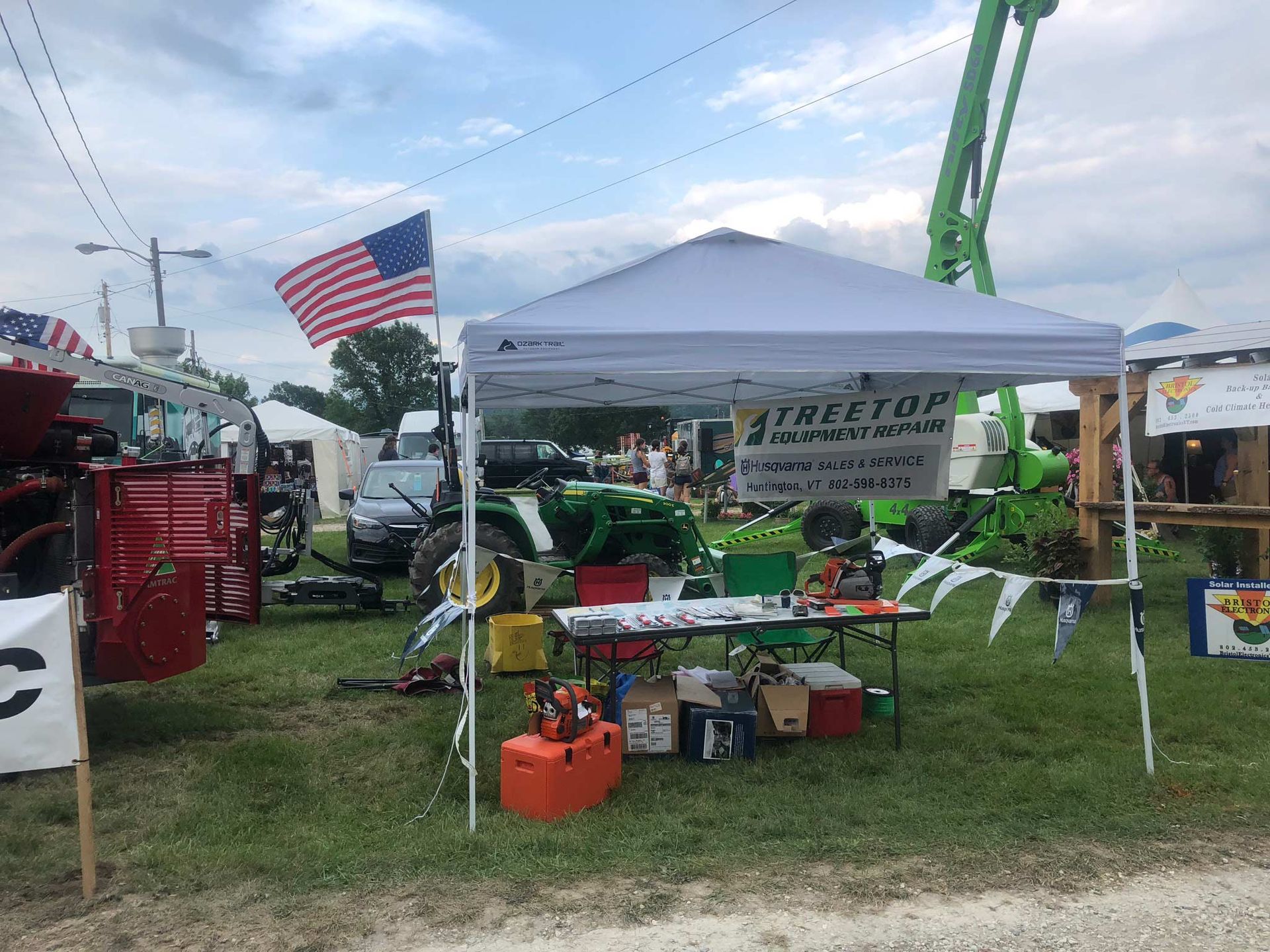A group of men are standing in front of a red tractor.