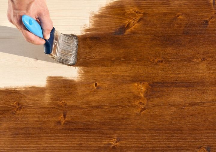 Liberty Painters and Decorators applying wood stain to a floor