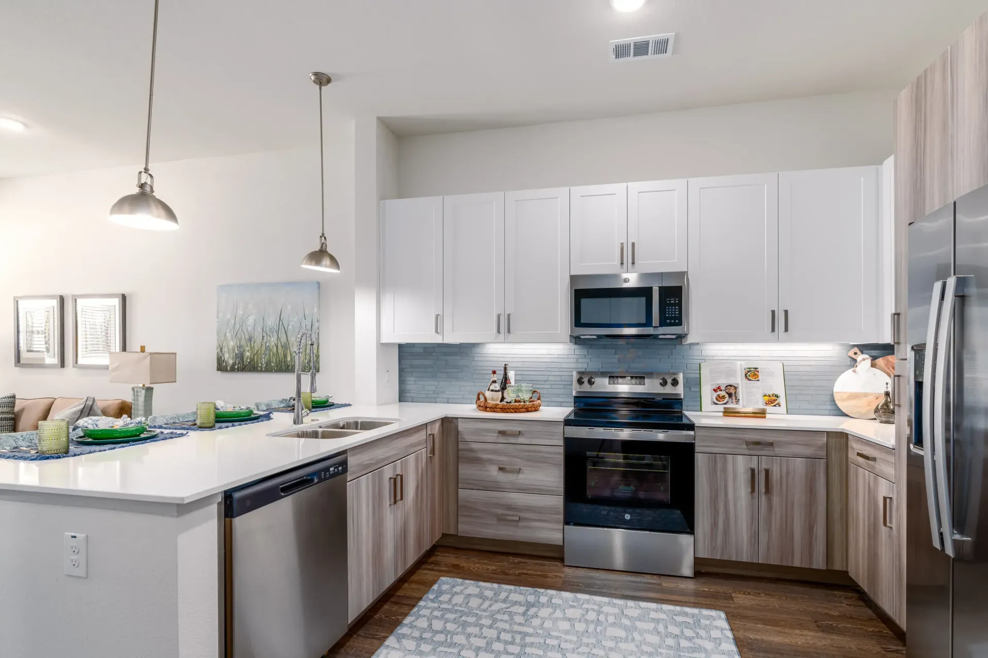 Modern apartment kitchen with white cabinets, stainless steel appliances, and an island.