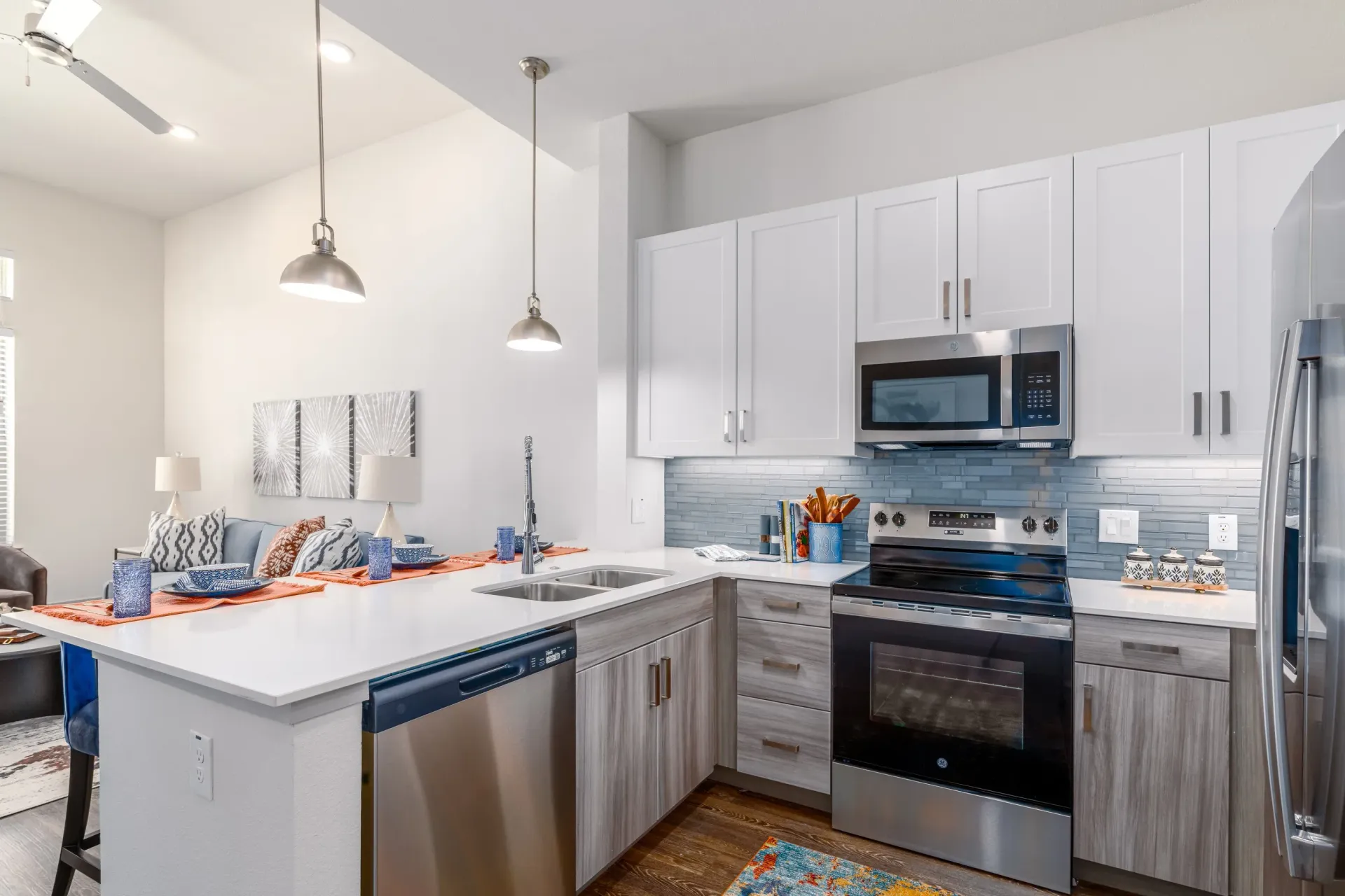 Open-concept kitchen with white cabinets, stainless steel appliances, and an island.
