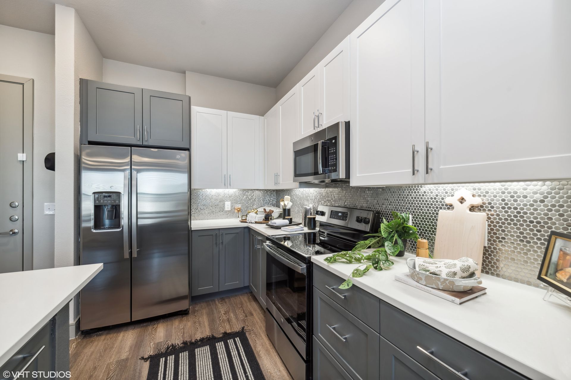 Modern kitchen with white cabinets, stainless steel appliances, and a gray mosaic backsplash