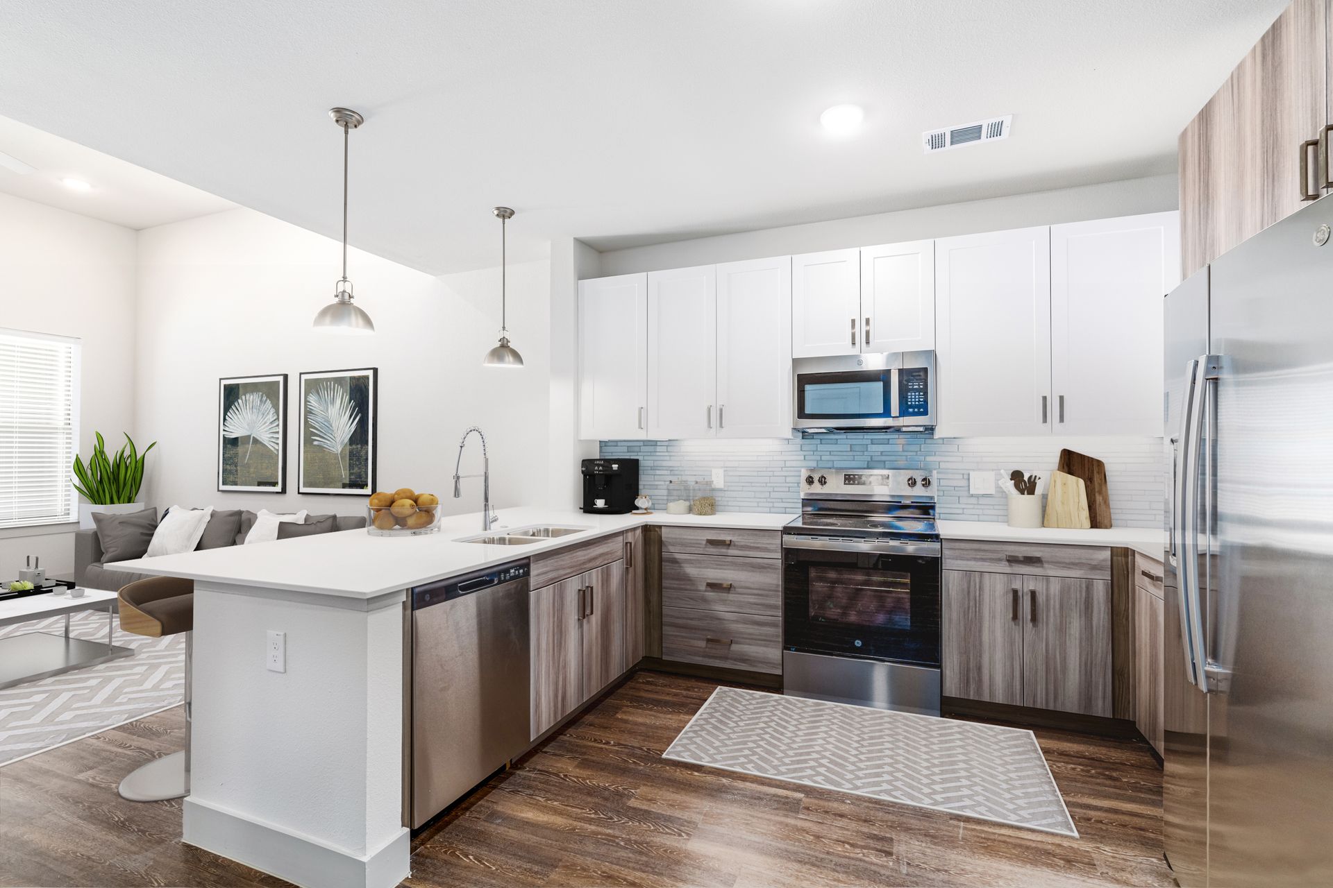Bright, modern kitchen with white cabinets, stainless appliances, and a large island with pendant lights.