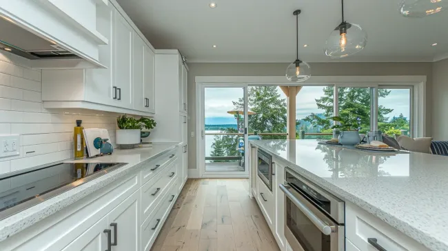 Vancouver kitchen renovation featuring custom kitchen cabinets, quartz countertops, tile backsplash installation, hardwood flooring, LED recessed lighting, and full-service kitchen remodeling in Vancouver BC.
Modern kitchen remodeling Vancouver BC with open-concept layout redesign, structural wall removal, large island installation, and premium quartz countertop upgrade.
Luxury kitchen renovation Vancouver showcasing marble waterfall island, bespoke cabinetry, integrated appliances, under-cabinet lighting, and professional design-build execution.