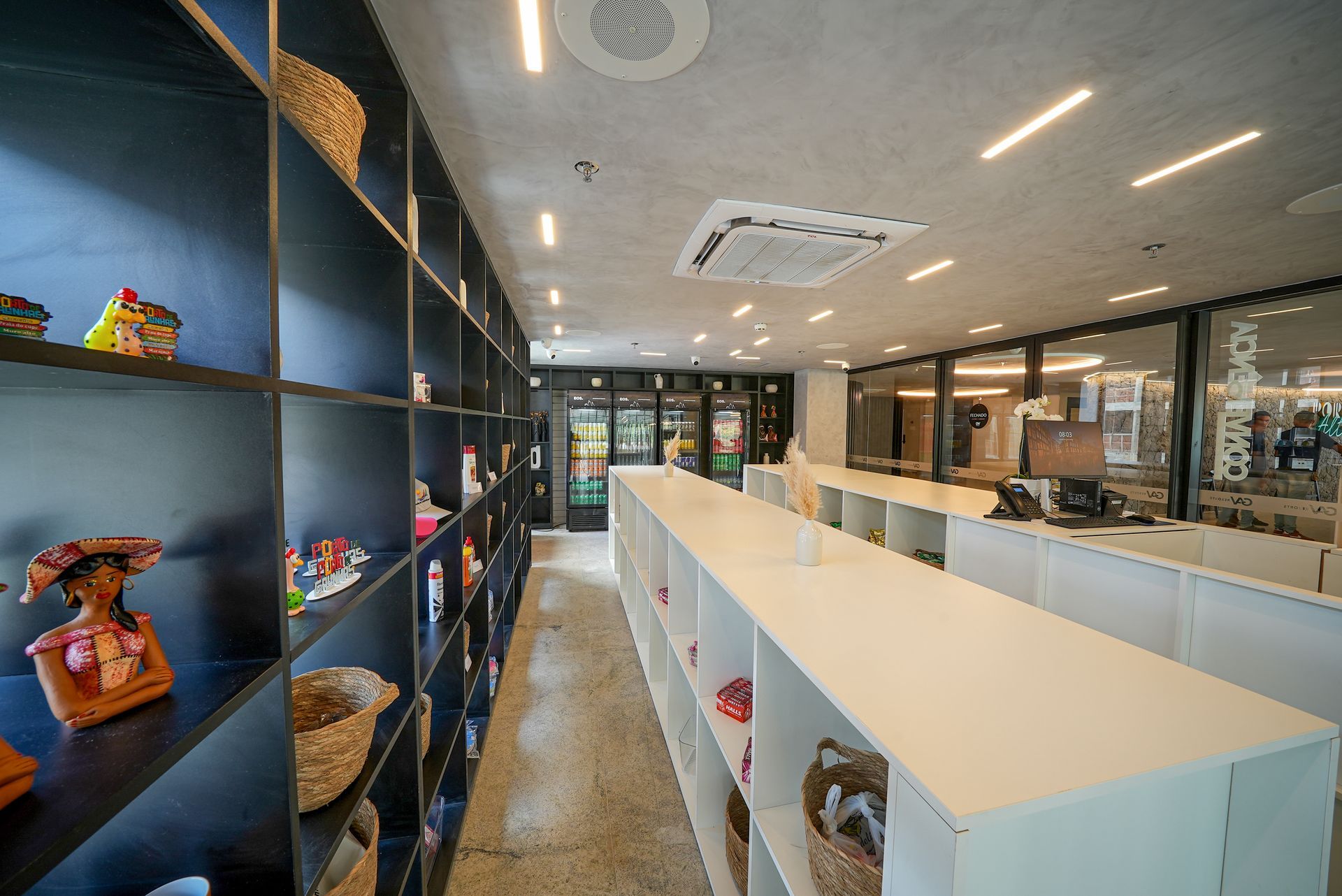 Um longo corredor cheio de prateleiras e um balcão em uma loja.