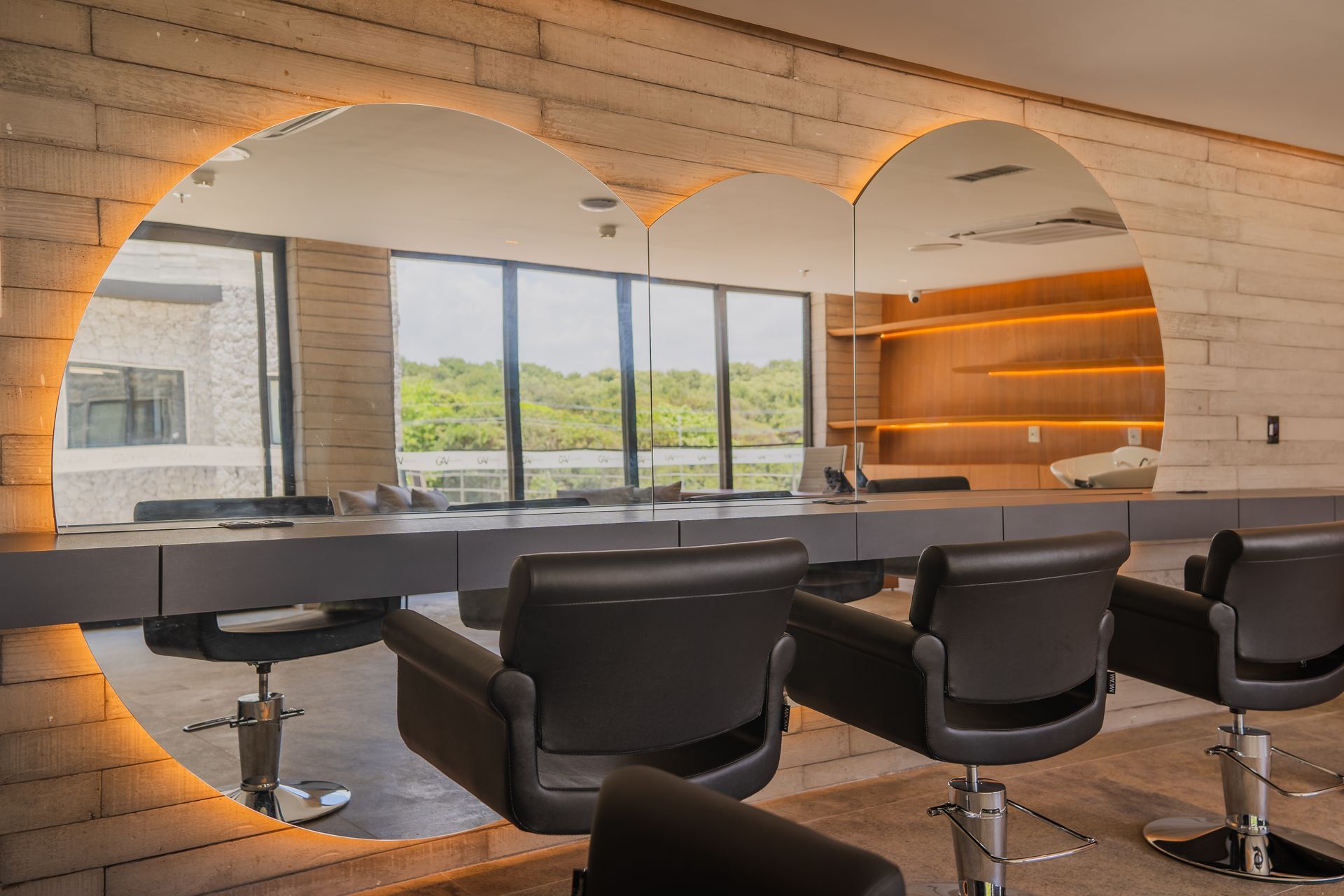 Um salão com um espelho em forma de coração na parede e cadeiras.