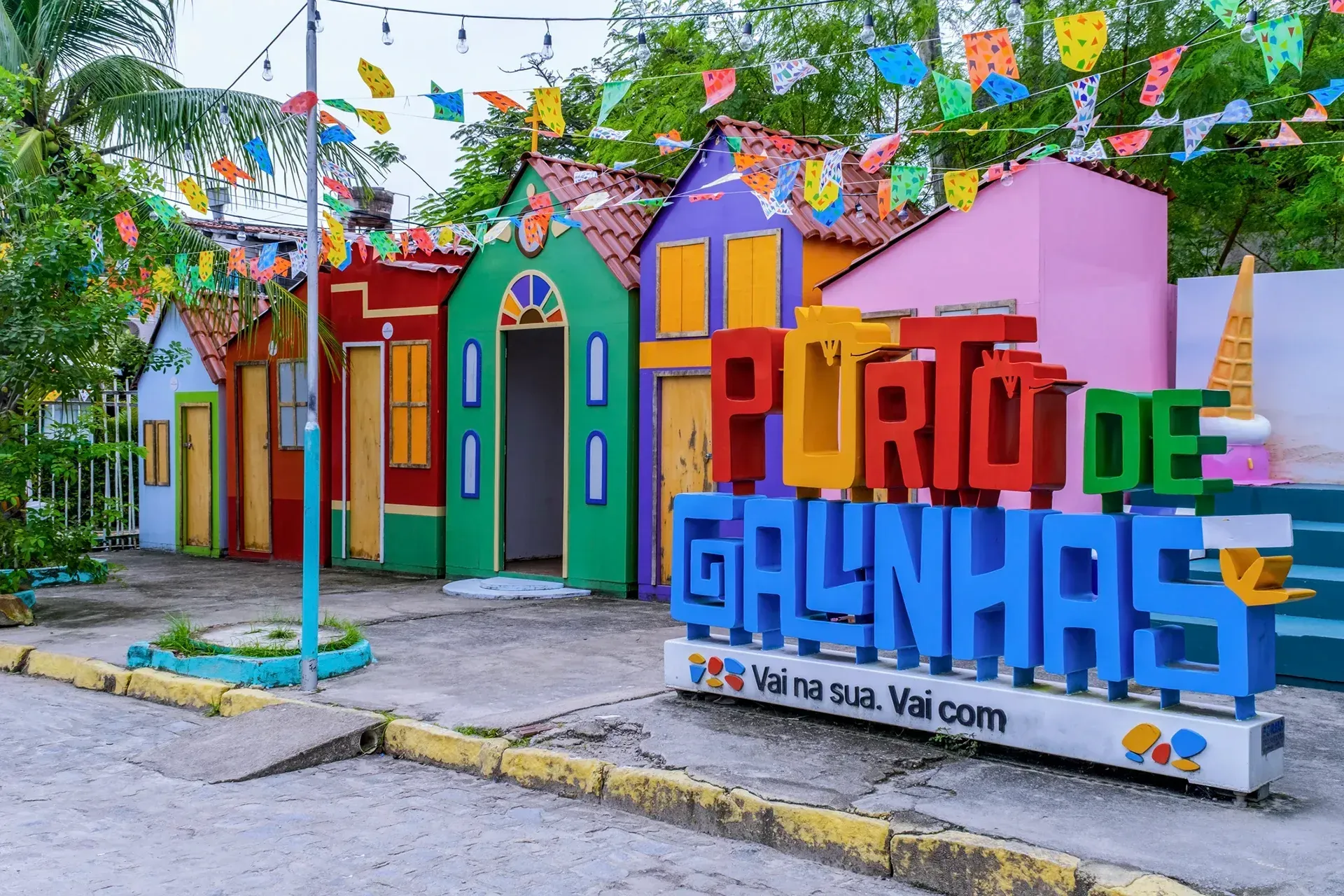 Uma placa que diz puro de galinhas fica em frente a uma fileira de casas coloridas