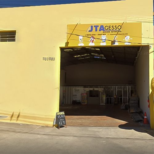 Um prédio amarelo com uma placa que diz jtagesso