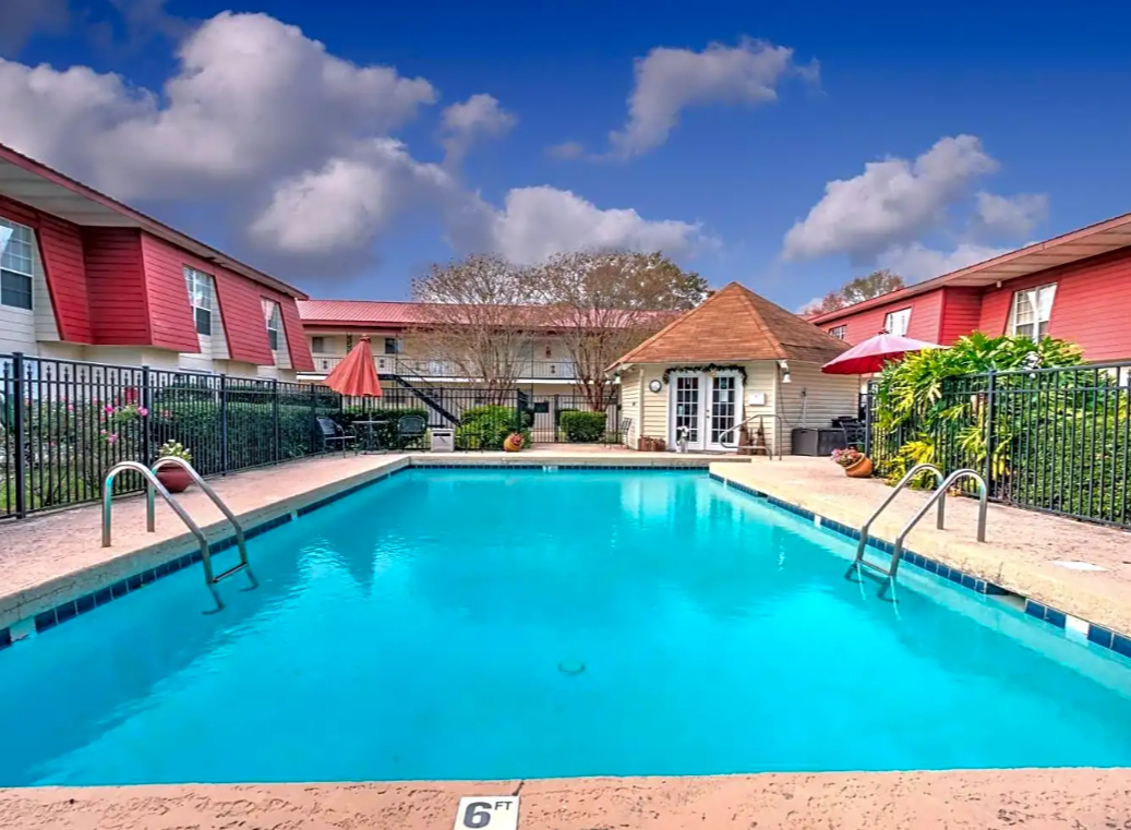 There is a large swimming pool in front of a building.