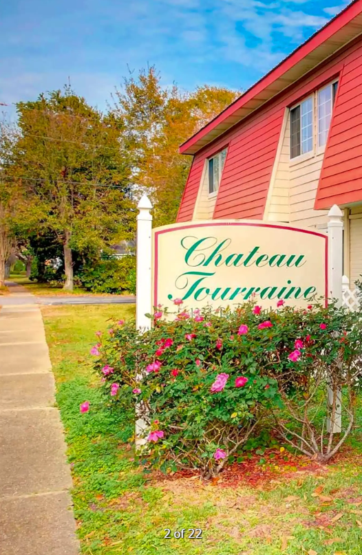 A sign for chateau touraine is in front of a house.