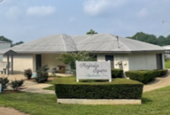 A white house with a sign in front of it.