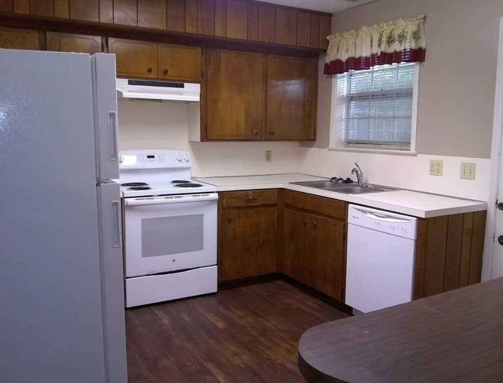A kitchen with white appliances and wooden cabinets
