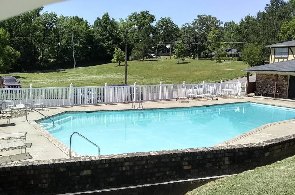 A large swimming pool with a white fence around it