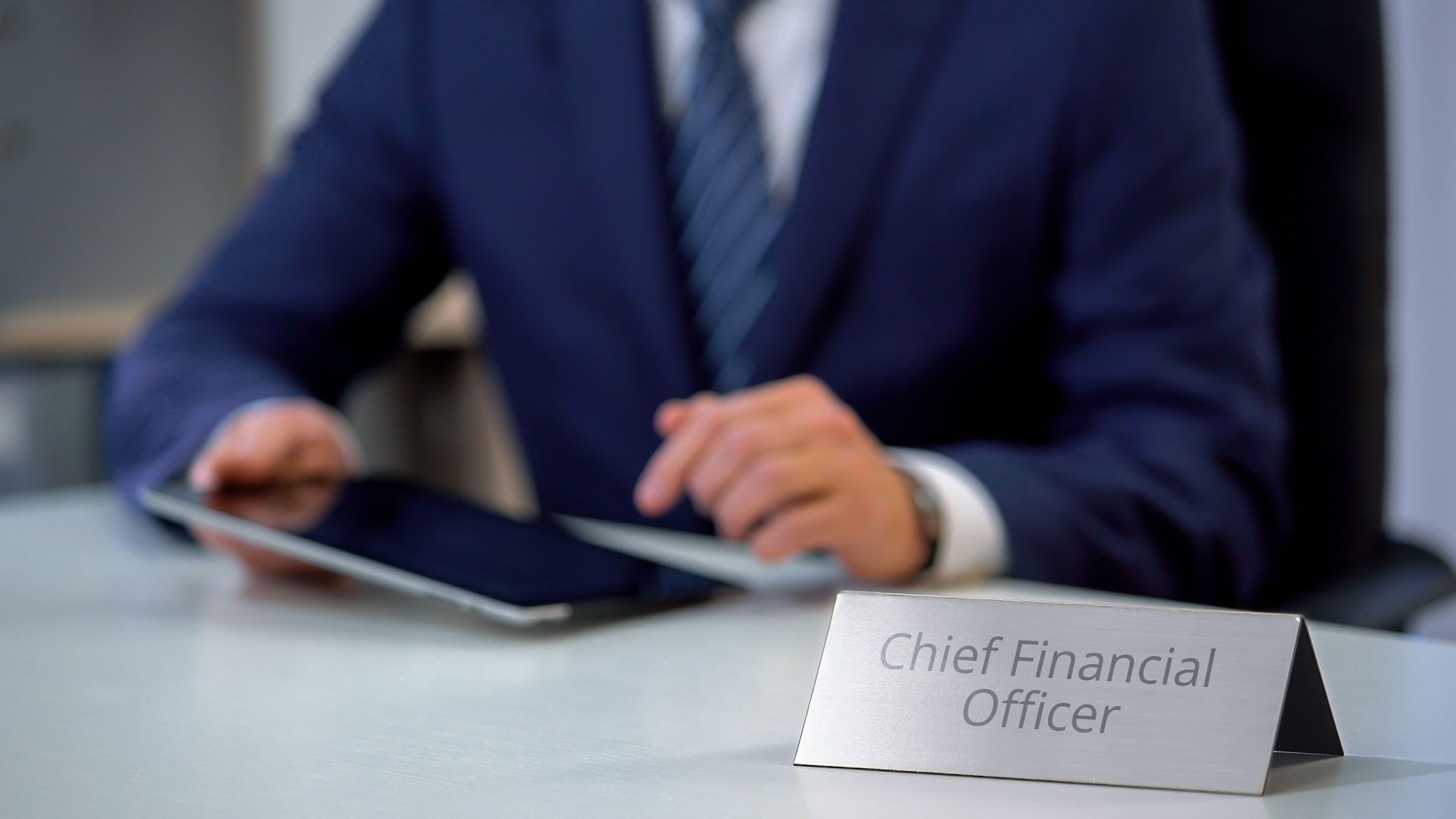 Chief Financial Officer at desk, using tablet.