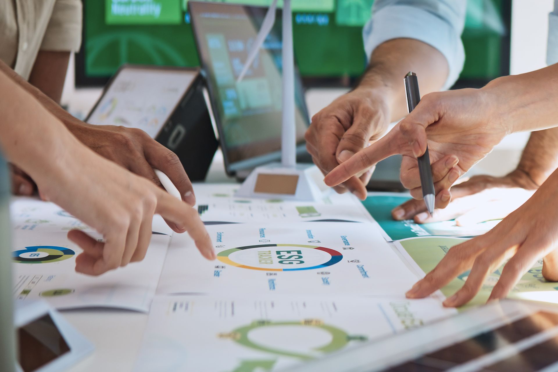 Two people in suits shaking hands in an office.