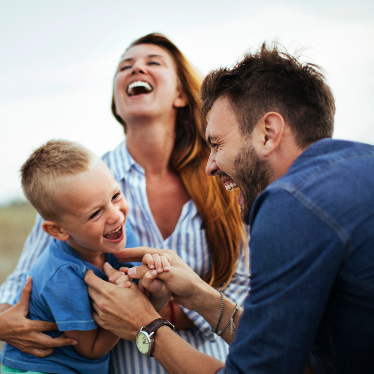Family smiles inside a car, driving on a sunny day.