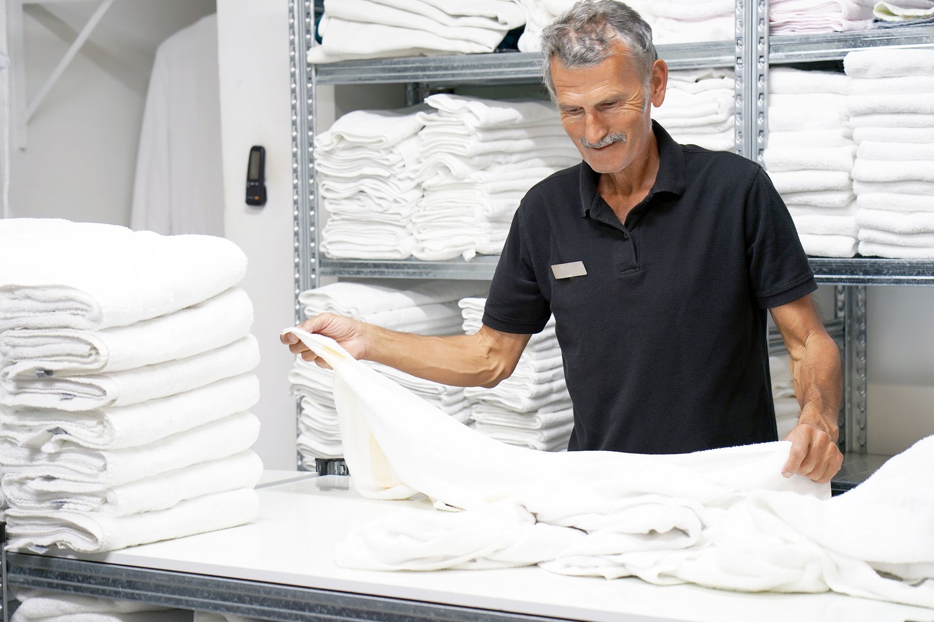 A man in a black shirt is working in a laundromat