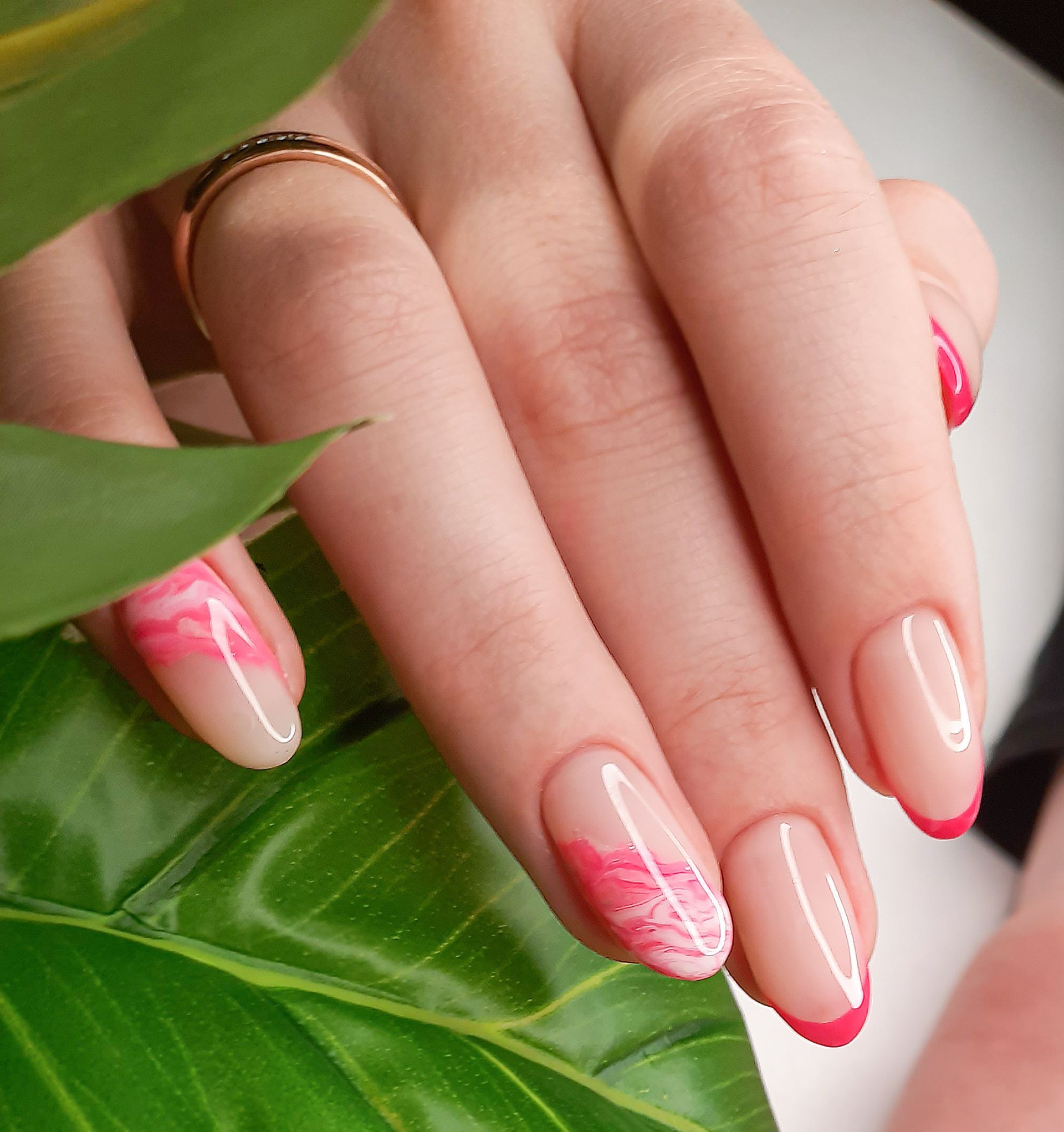 Mano curata con french manicure e dettagli floreali rosa.