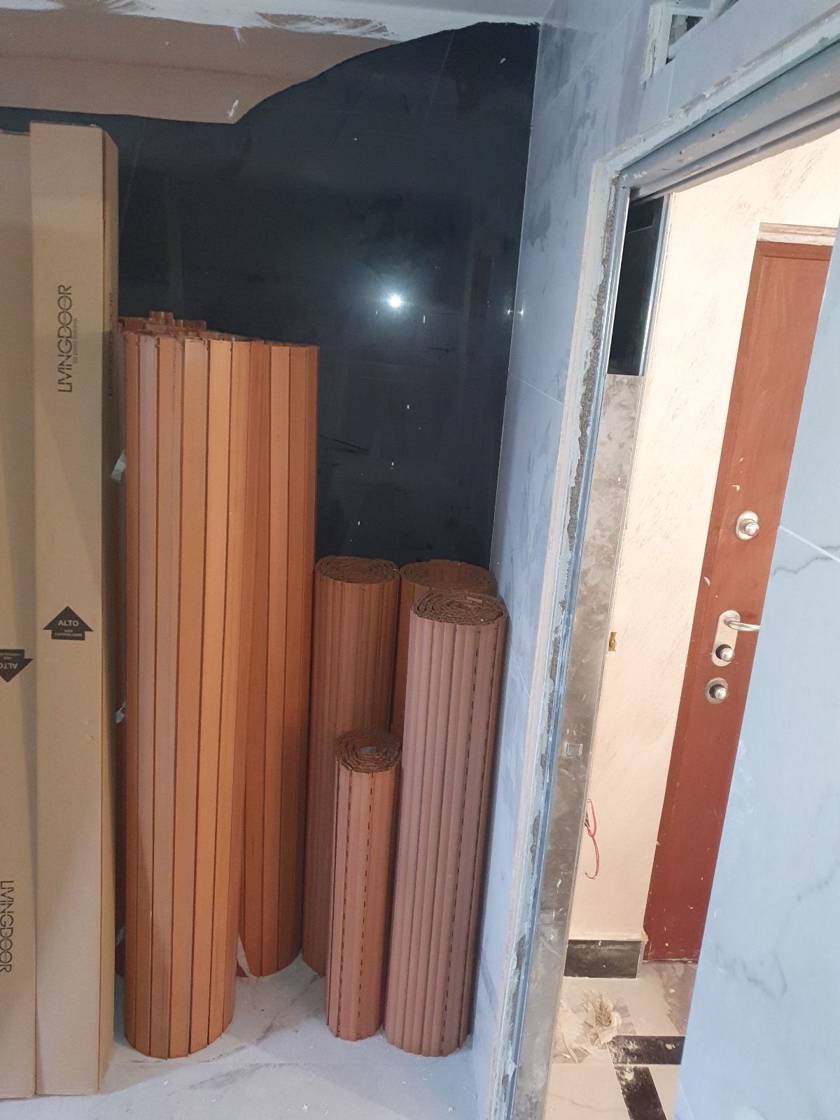 Un mucchio di rotoli di legno sono accatastati uno sopra l'altro in una stanza.