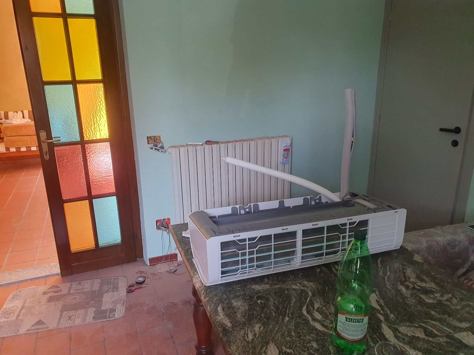 Un condizionatore è appoggiato su un tavolo accanto a una bottiglia d'acqua.