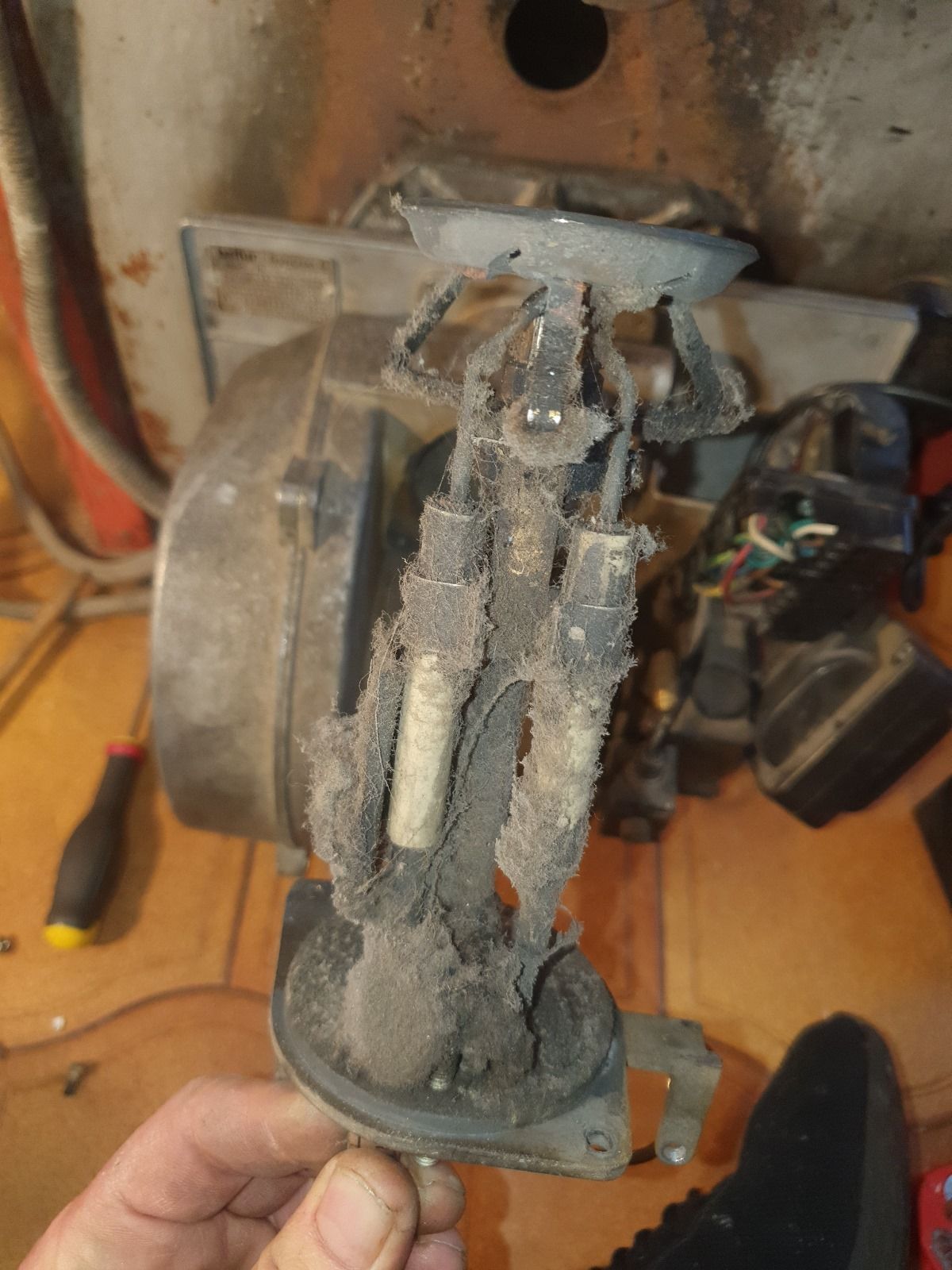 Una persona tiene in mano un pezzo di metallo sporco.