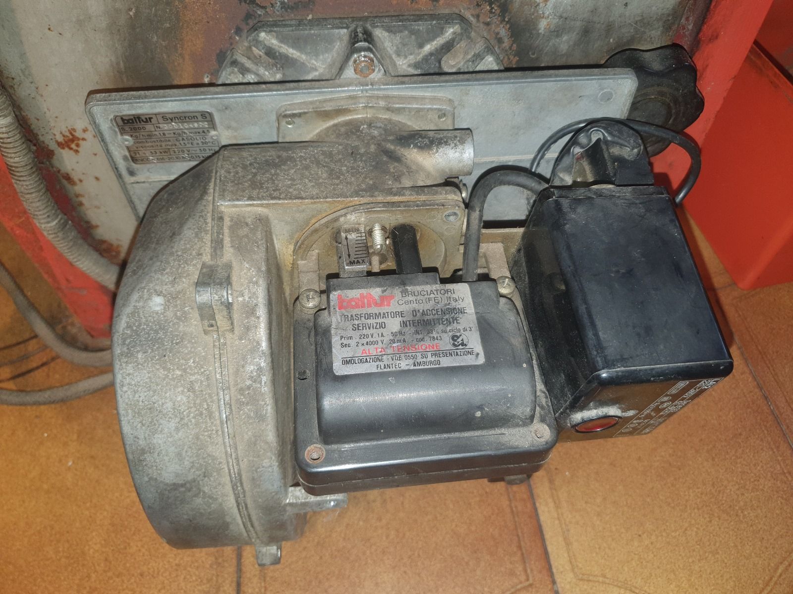 Un motore è appoggiato su un pavimento piastrellato accanto a una stufa.