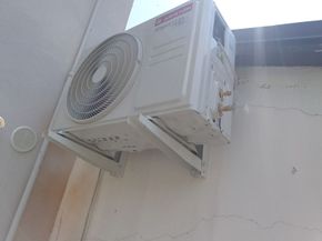 Un condizionatore bianco è montato sul lato di un edificio.