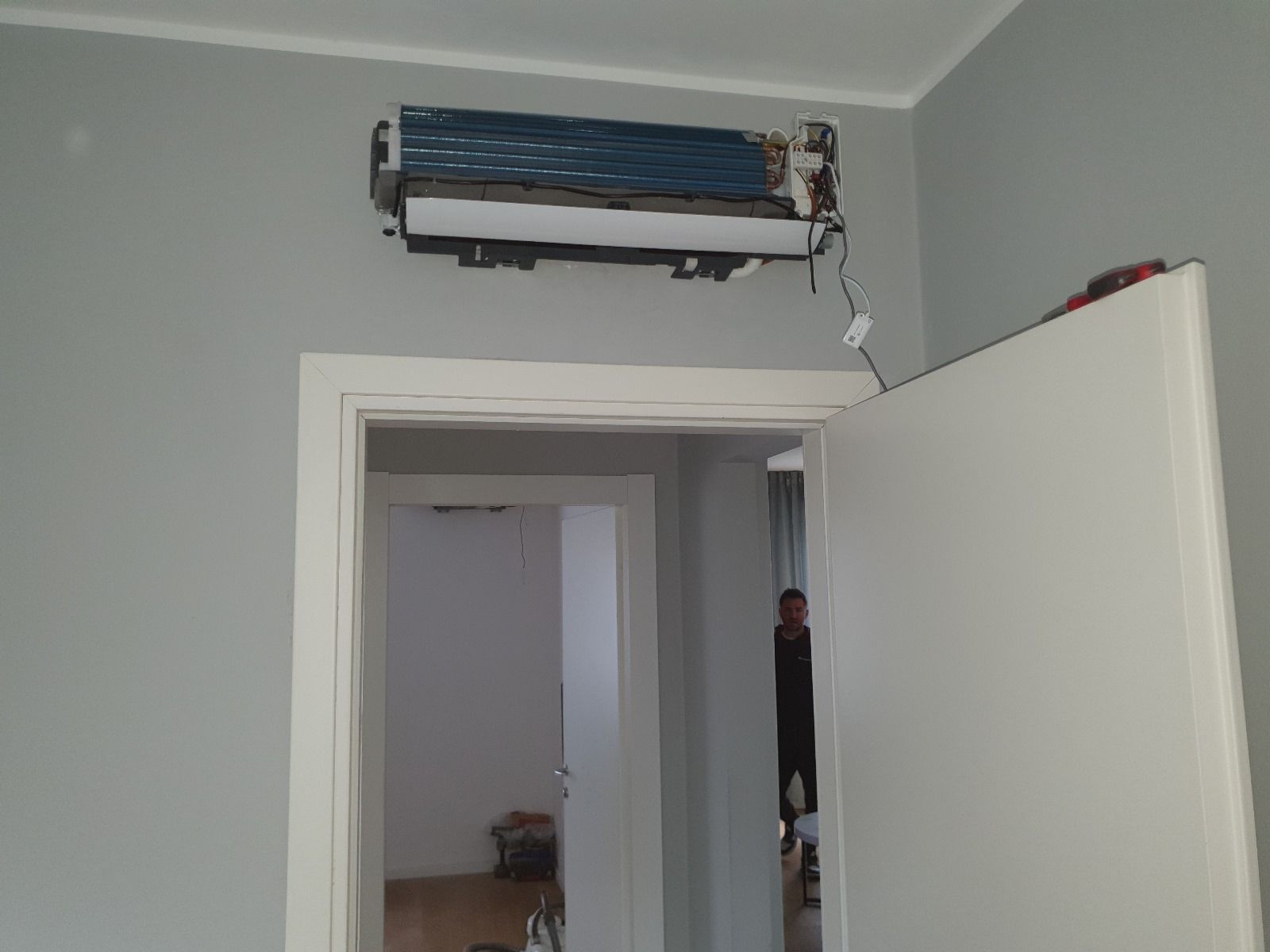 Una stanza con una porta aperta e un condizionatore d'aria montato a parete.