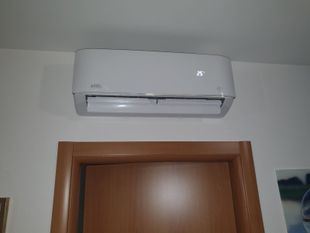 Un condizionatore bianco è montato sulla parete sopra una porta.