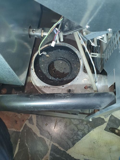 Una persona è in piedi accanto a una stufa con un buco.